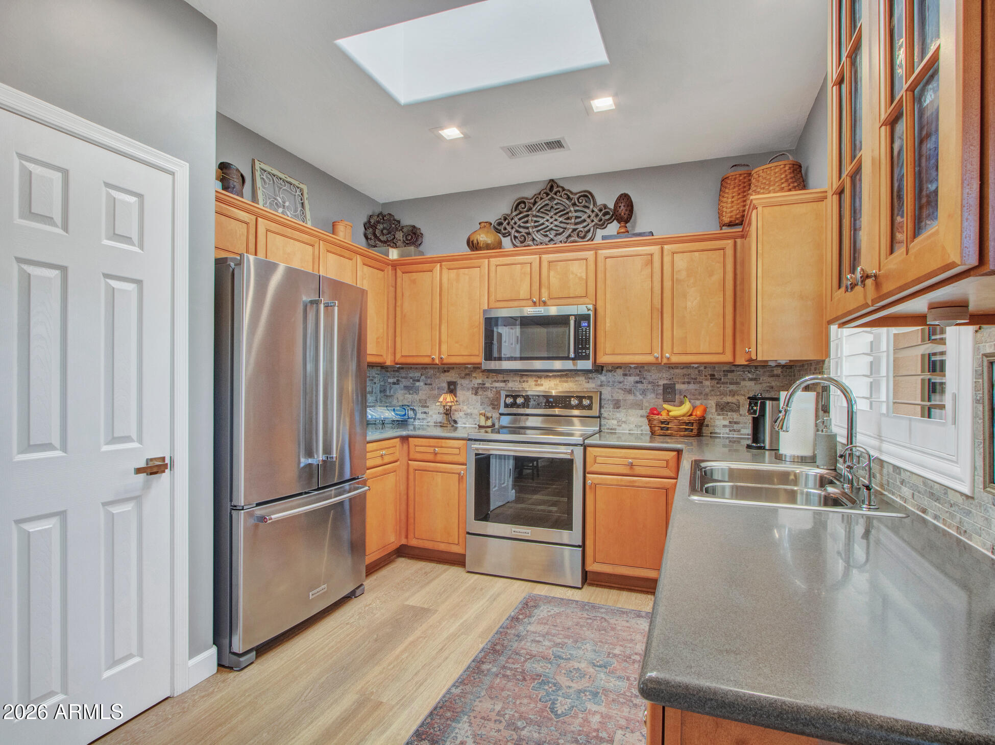 19760 North Los Altos Way Surprise, AZ 85374 - Photo 35 of 53 a kitchen with stainless steel appliances granite countertop a refrigerator a sink dishwasher a stove with wooden cabinets and floor