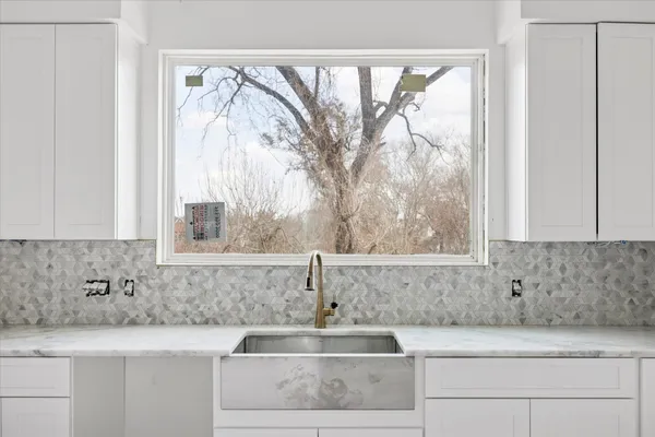 a bathroom with a granite countertop sink and window