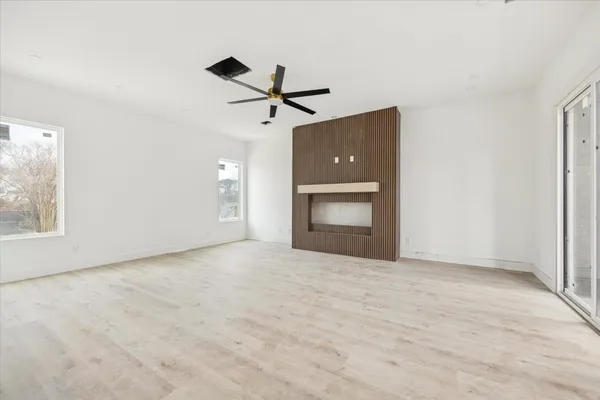 a view of an empty room with a fireplace and a window