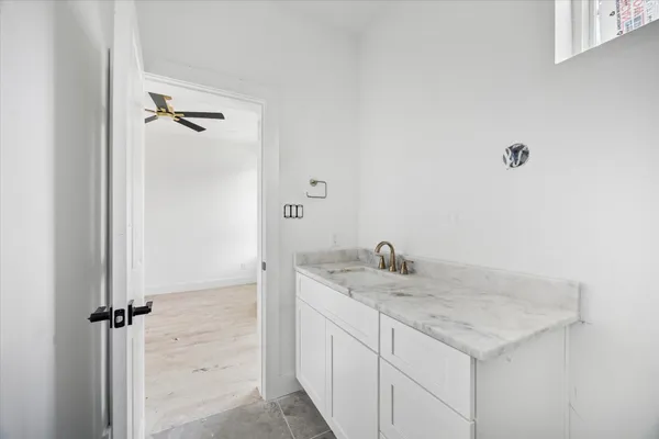 a bathroom with a granite countertop sink and a mirror