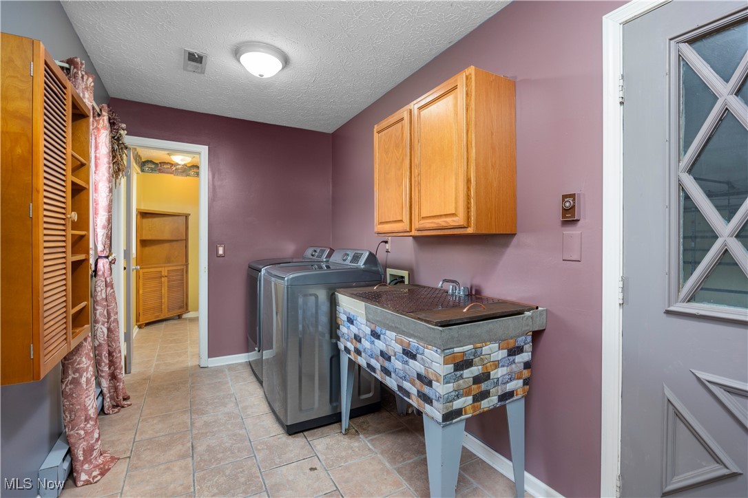 43995 Middle Ridge Road Lorain, OH 44053 - Photo 14 of 49 First floor Laundry room featuring independent washer and dryer, cabinet space & ceramic tiled flooring.