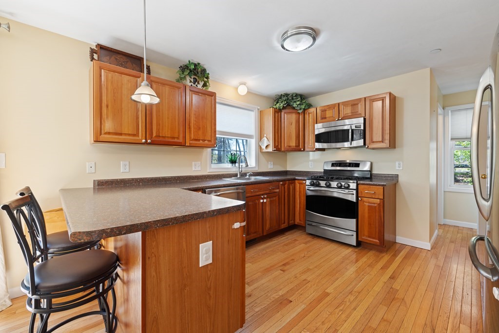 9 Evergreen Road Salem, NH 03079 - Photo 12 of 41 a kitchen with granite countertop a stove top oven a sink dishwasher a dining table and chairs with wooden floor