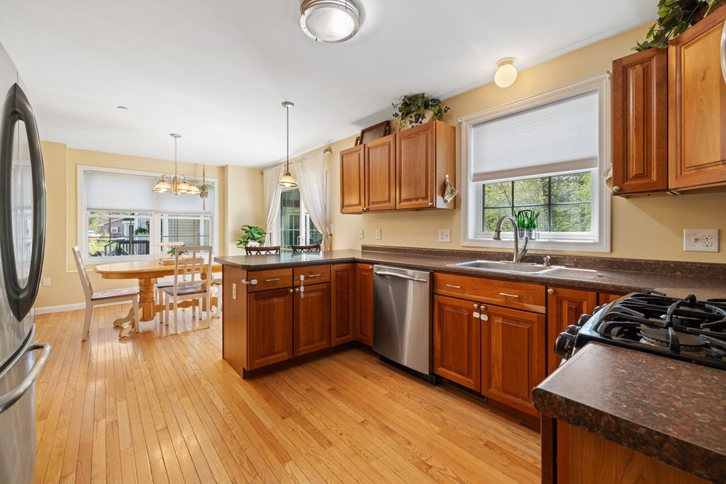 9 Evergreen Road Salem, NH 03079 - Photo 13 of 41 a kitchen with stainless steel appliances granite countertop wooden floors stove top oven and sink