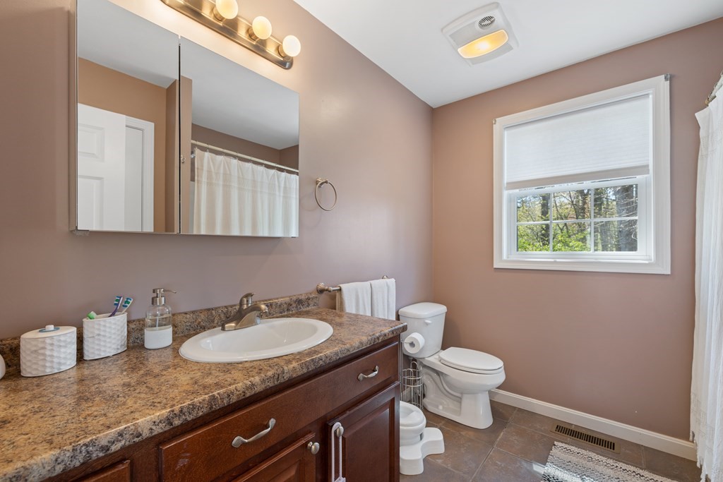 9 Evergreen Road Salem, NH 03079 - Photo 15 of 41 a bathroom with a granite countertop sink a toilet and mirror