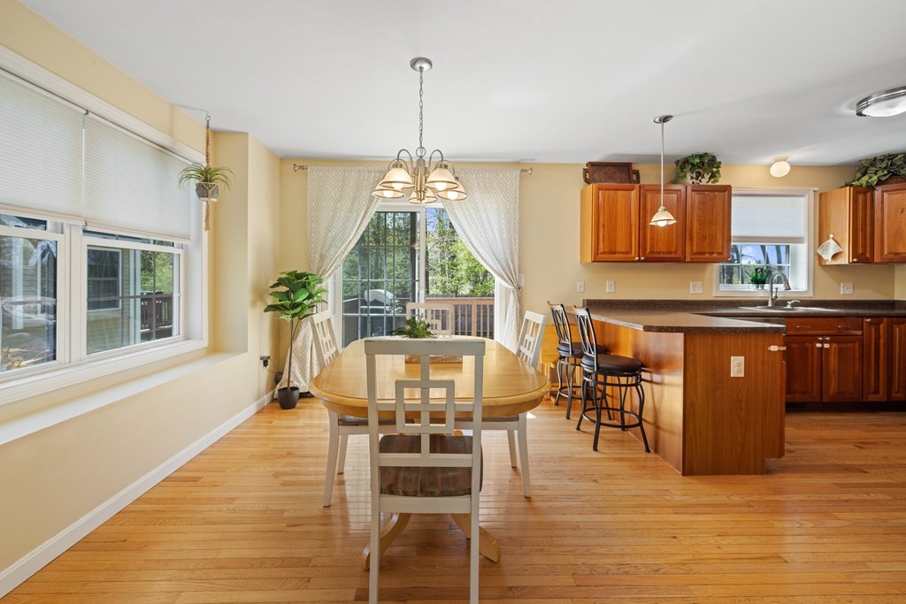 9 Evergreen Road Salem, NH 03079 - Photo 8 of 41 a dining hall with stainless steel appliances kitchen island granite countertop a table chairs and a wooden floor