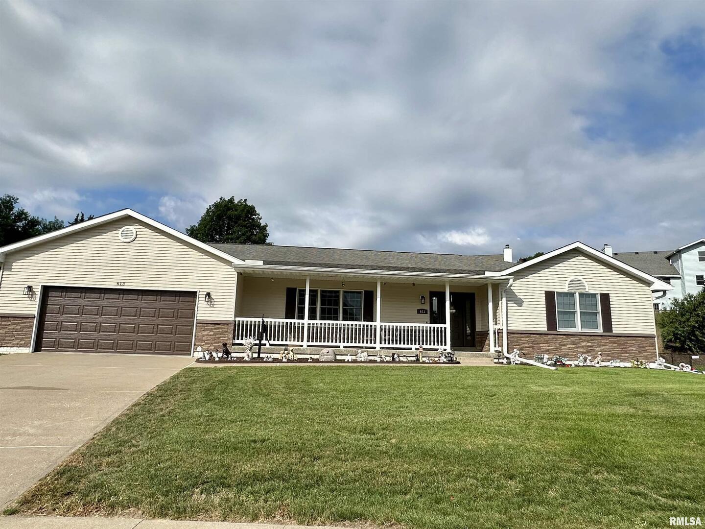 a front view of a house with a garden and yard