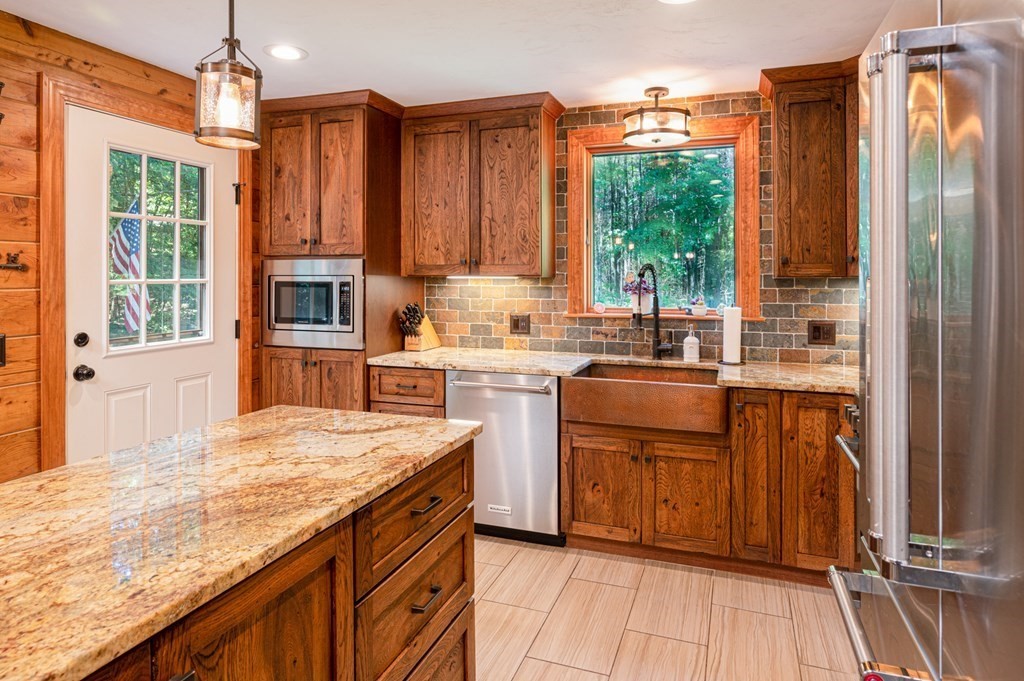769 Mason Road Holden, MA 01522 - Photo 8 of 29 a kitchen with stainless steel appliances granite countertop a refrigerator a sink dishwasher and wooden cabinets with wooden floor