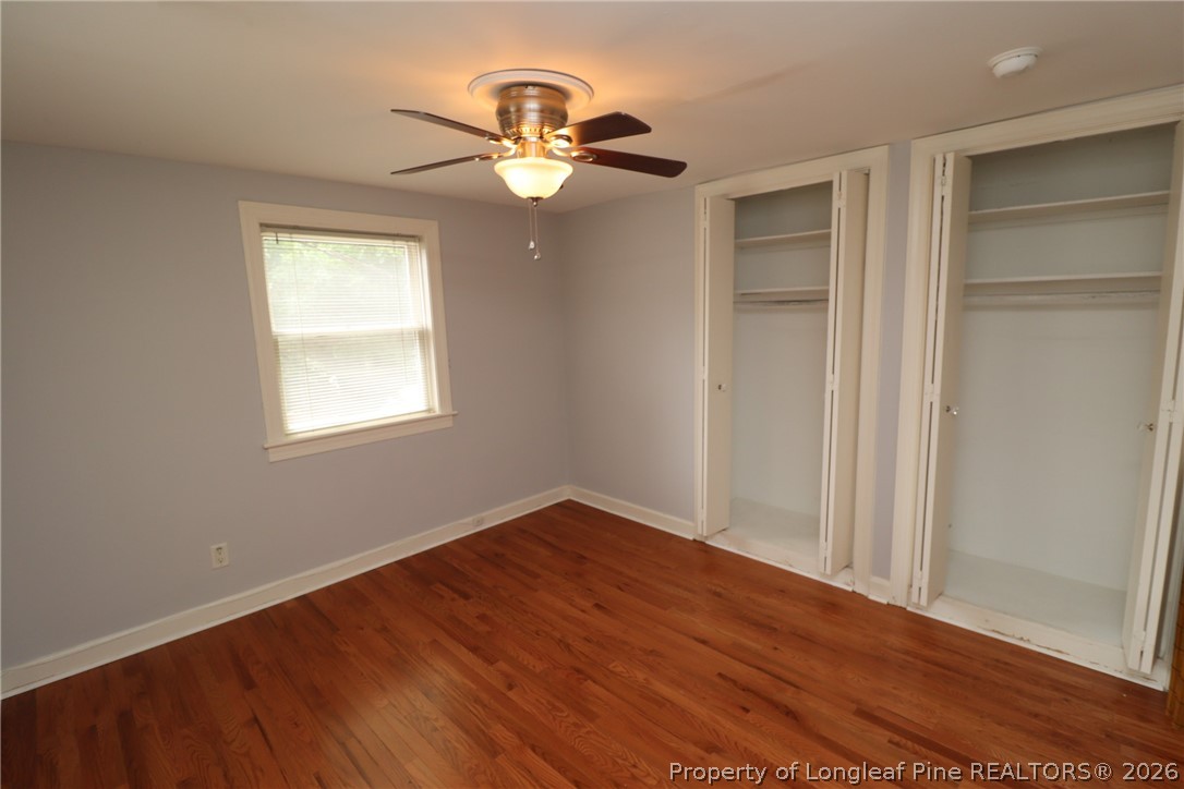1000 Nichols Drive Raleigh, NC 27605 - Photo 19 of 22 an empty room with wooden floor chandelier fan and windows