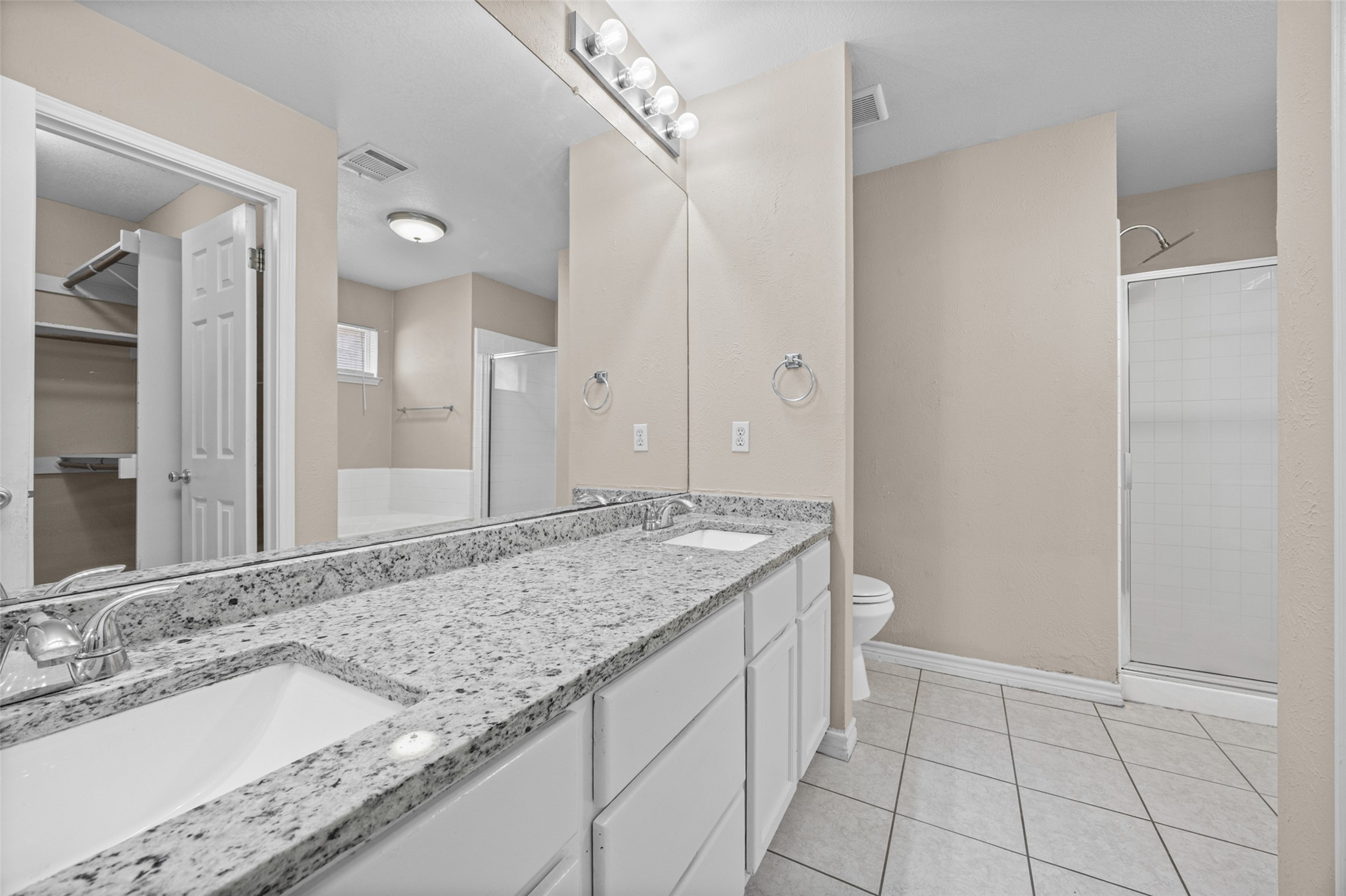 2432 Roundabout Lane Round Rock, TX 78664 - Photo 13 of 22 Double vanity with stone counters provides ample space and elegant finishes in this bathroom.