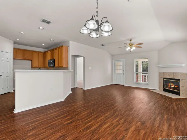 a view of a livingroom with wooden floor and a kitchen