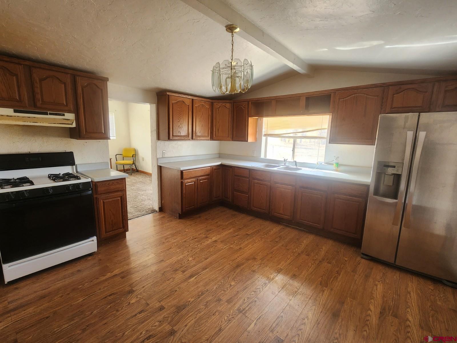 23227 County Road J.2 San Luis, CO 81152 - Photo 5 of 16 a kitchen with granite countertop a refrigerator and a stove top oven