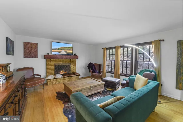 a living room with furniture fireplace and a large window