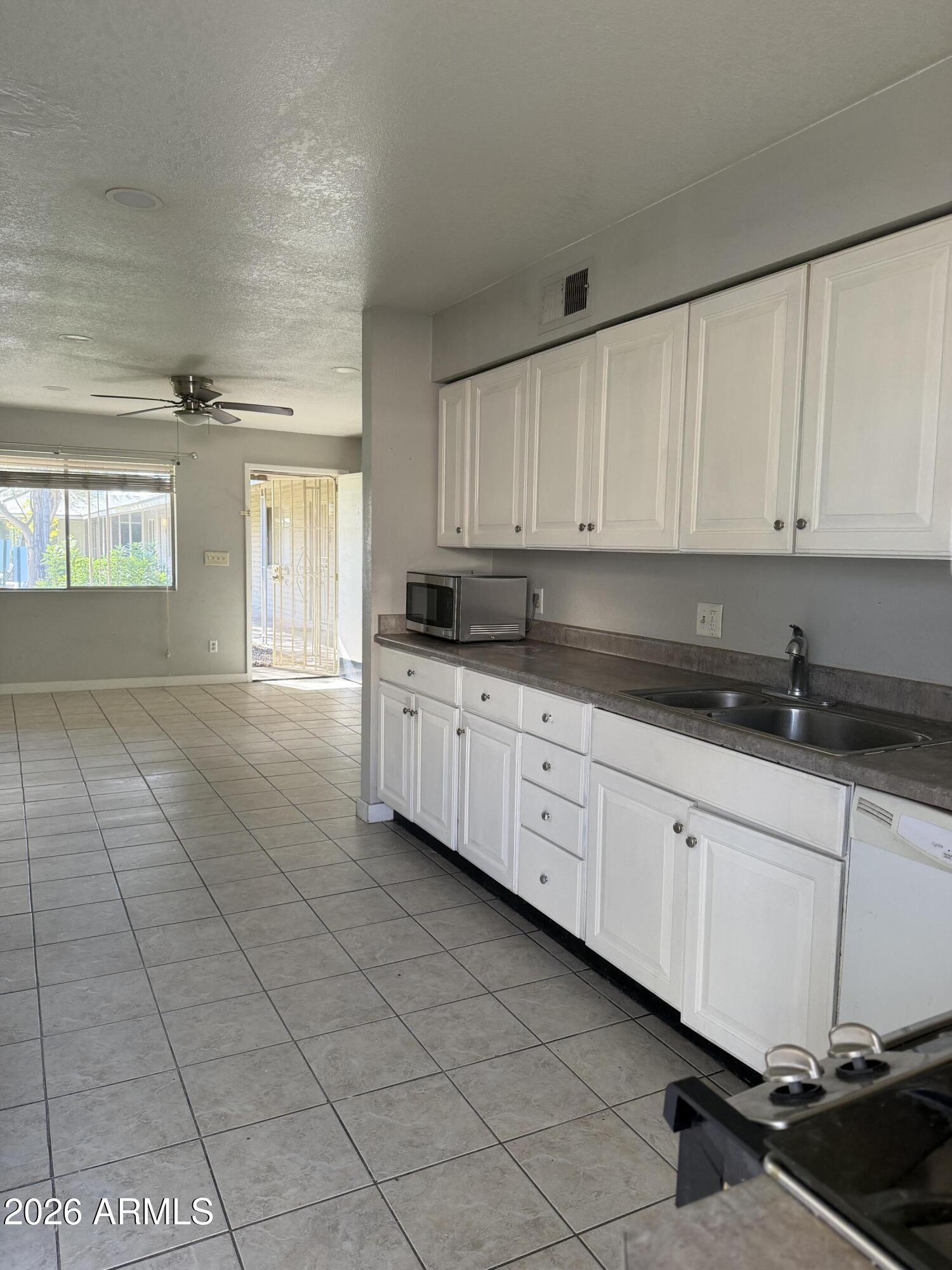 6819 North 12th Street, Unit 2 Phoenix, AZ 85014 - Photo 4 of 17 a kitchen with stainless steel appliances granite countertop a sink a stove and cabinets