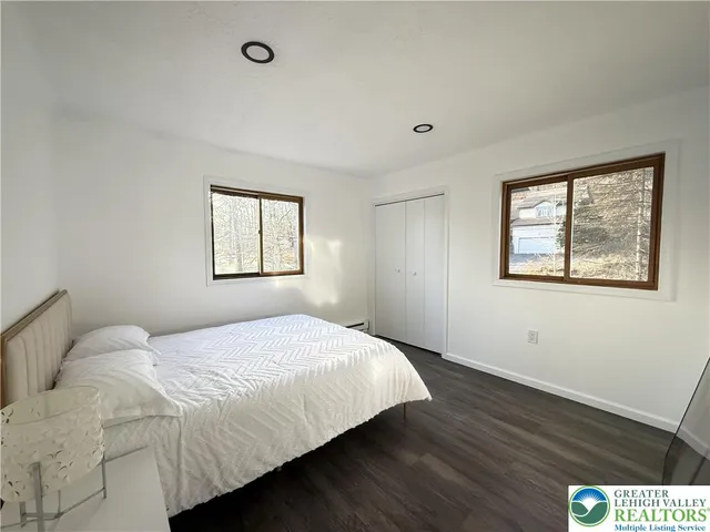 a living room with furniture and a dining table with wooden floor