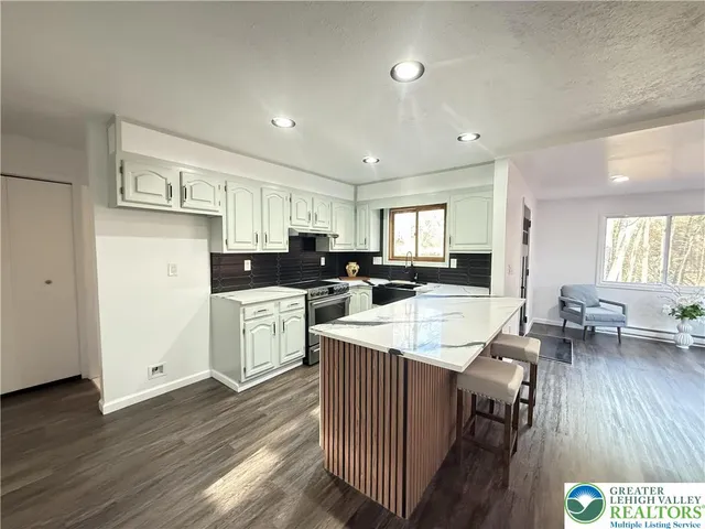 a kitchen with sink refrigerator dining table and chairs