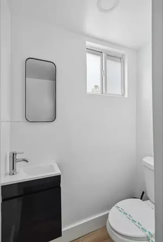 a bathroom with a toilet a sink a vanity and mirror