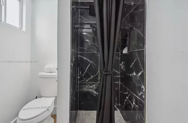 a bathroom with a toilet and a shower