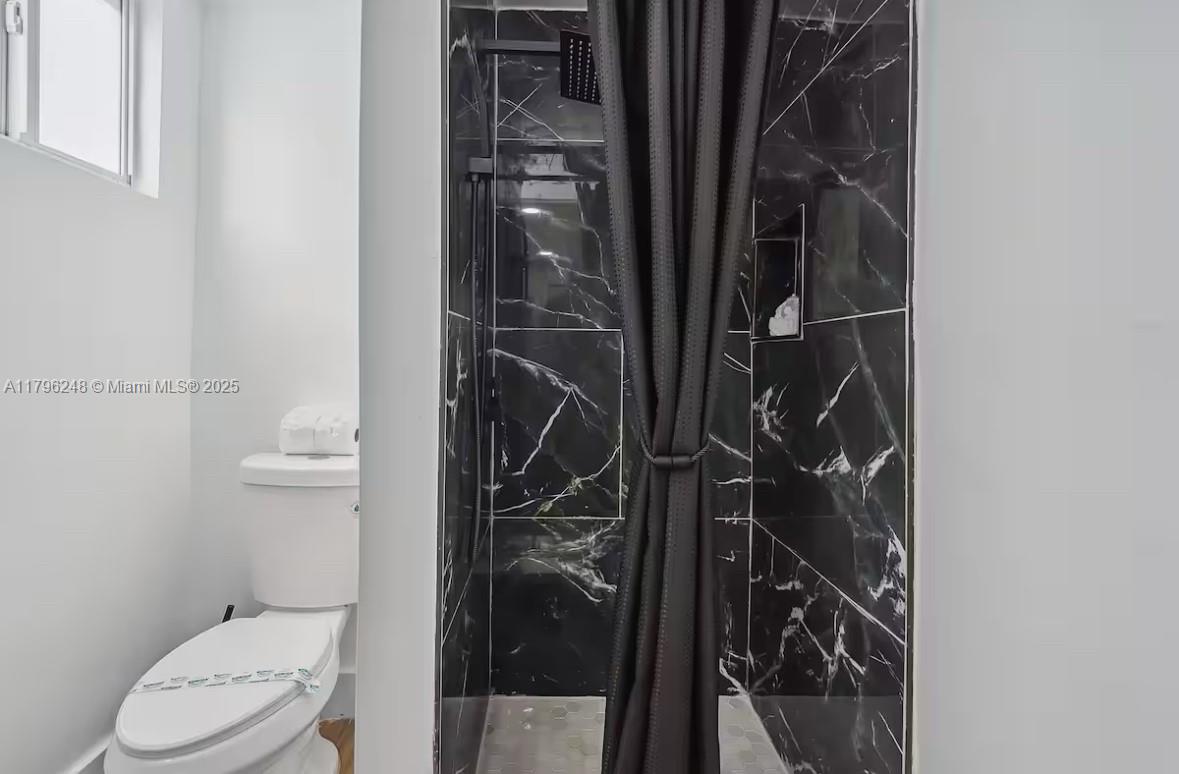 310 Oregon Street, Unit 3 Hollywood, FL 33019 - Photo 15 of 17 a bathroom with a toilet and a shower