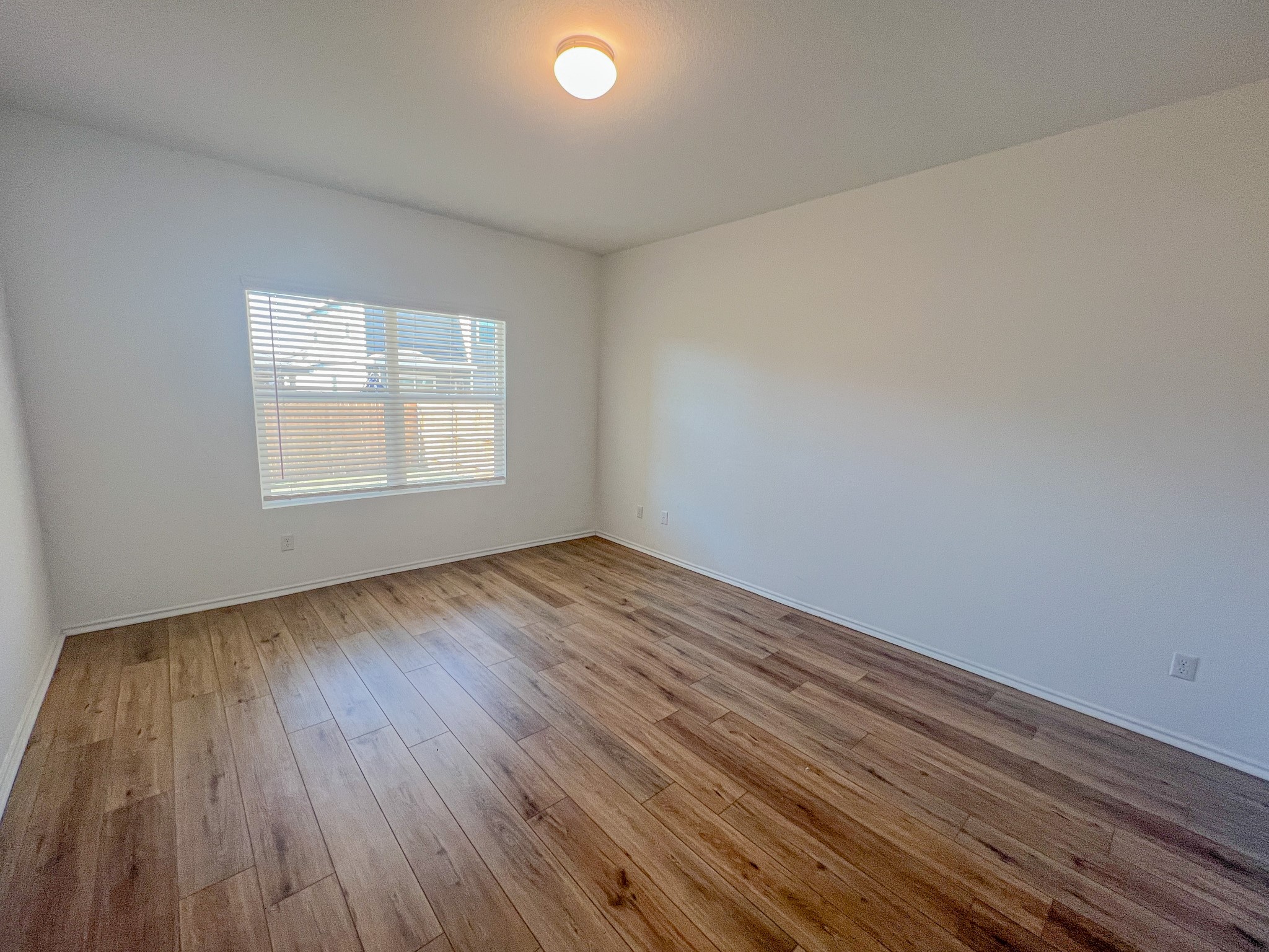 438 Perfect World Loop Jarrell, TX 76537 - Photo 9 of 35 an empty room with wooden floor and windows
