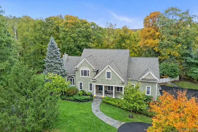 a view of a big house with a big yard and large trees