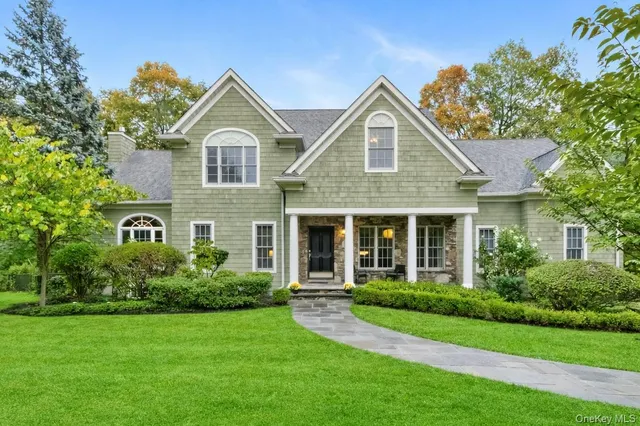 a front view of a house with a yard and trees
