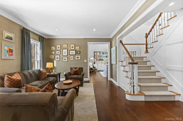 a living room with furniture and hard wood flooring