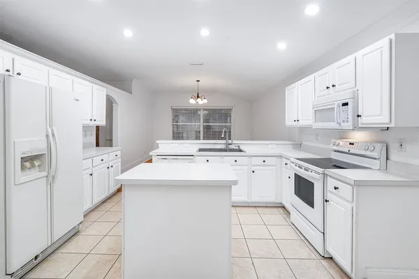 a kitchen with white cabinets and white appliances