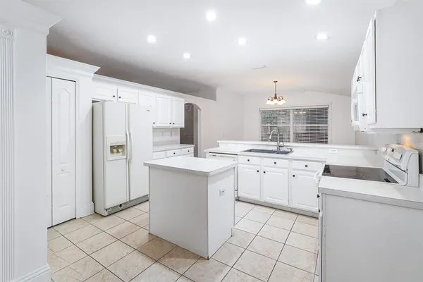 a kitchen with white cabinets and white appliances