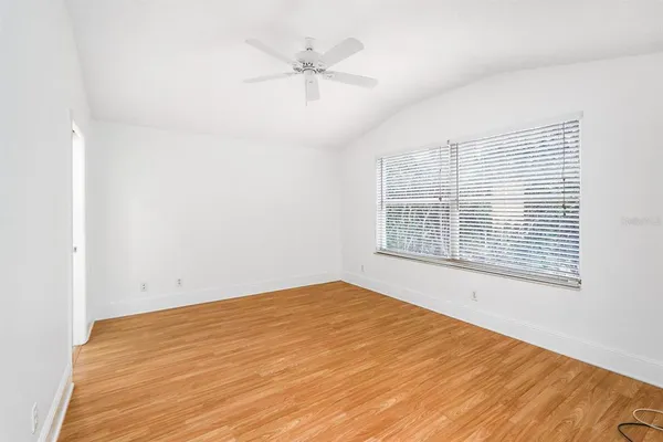 a view of an empty room with a window and a ceiling fan