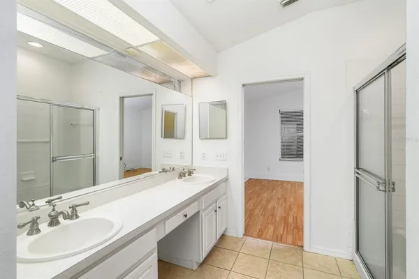a bathroom with a double vanity sink mirror and shower
