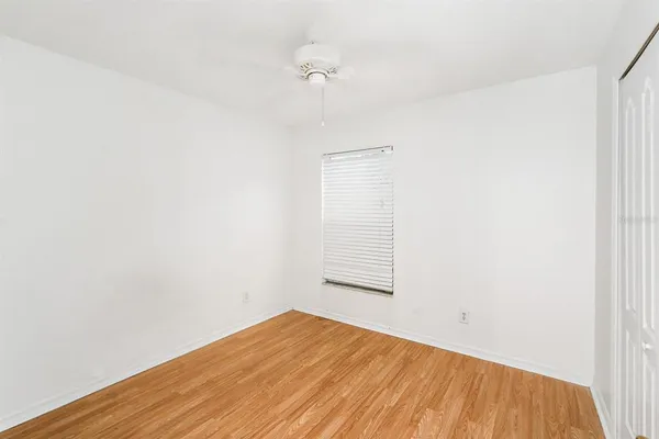 a view of a room that has wooden floor and a window