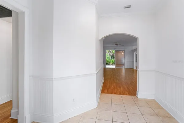 a view of a hallway with wooden floor and a living room