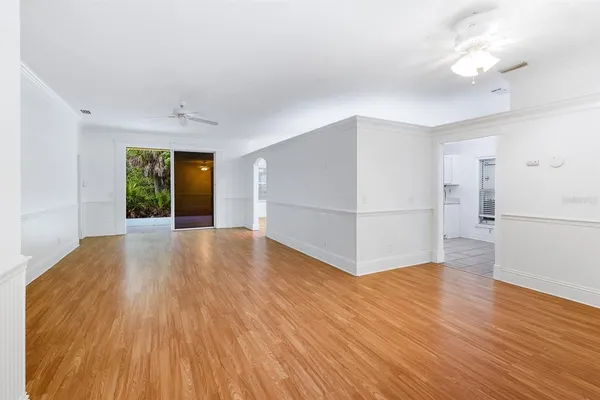 a view of a big room with wooden floor and a kitchen
