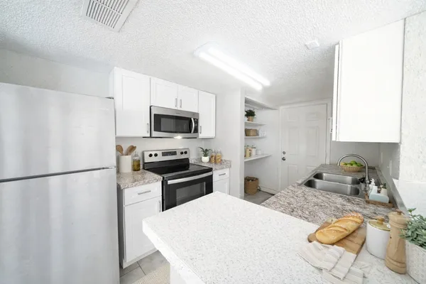 a kitchen with a refrigerator a stove a microwave and cabinets