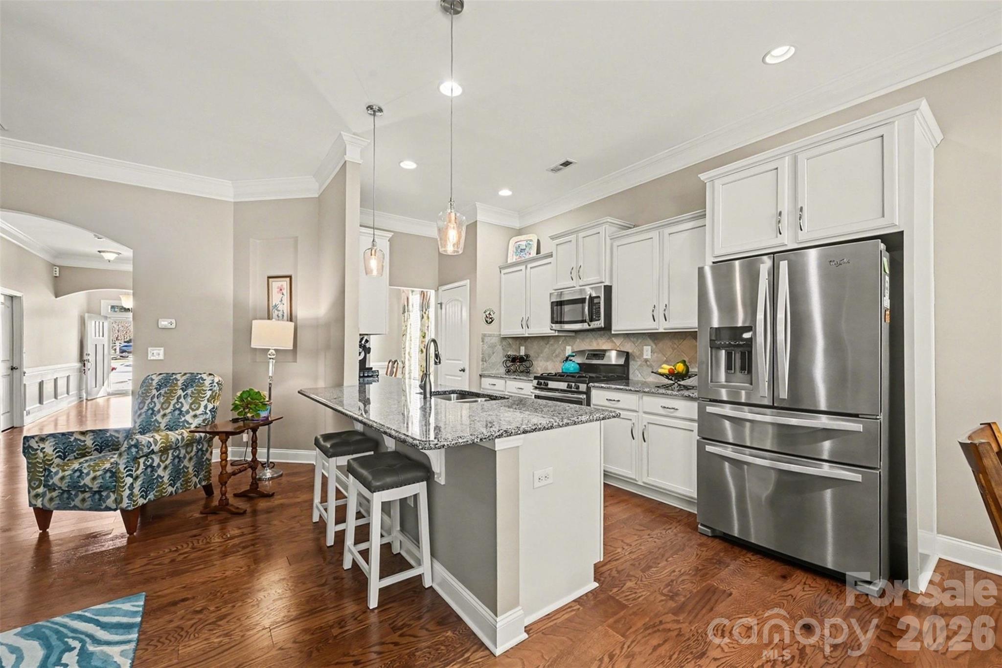 3059 Cricket Lane Lancaster, SC 29720 - Photo 10 of 32 a kitchen with granite countertop a refrigerator a stove a sink and white cabinets with wooden floor