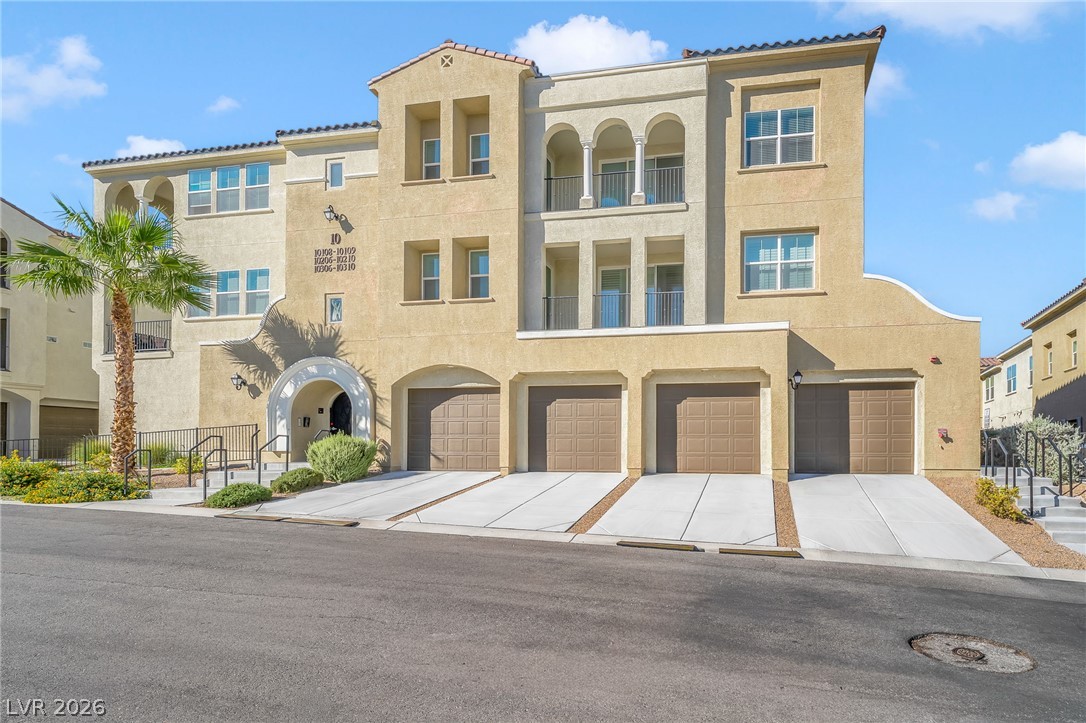 2555 Hampton Road, Unit 10108 Henderson, NV 89052 - Photo 2 of 23 Mediterranean-inspired multi-family architecture features arched details, stucco finishes, and integrated garage bays.