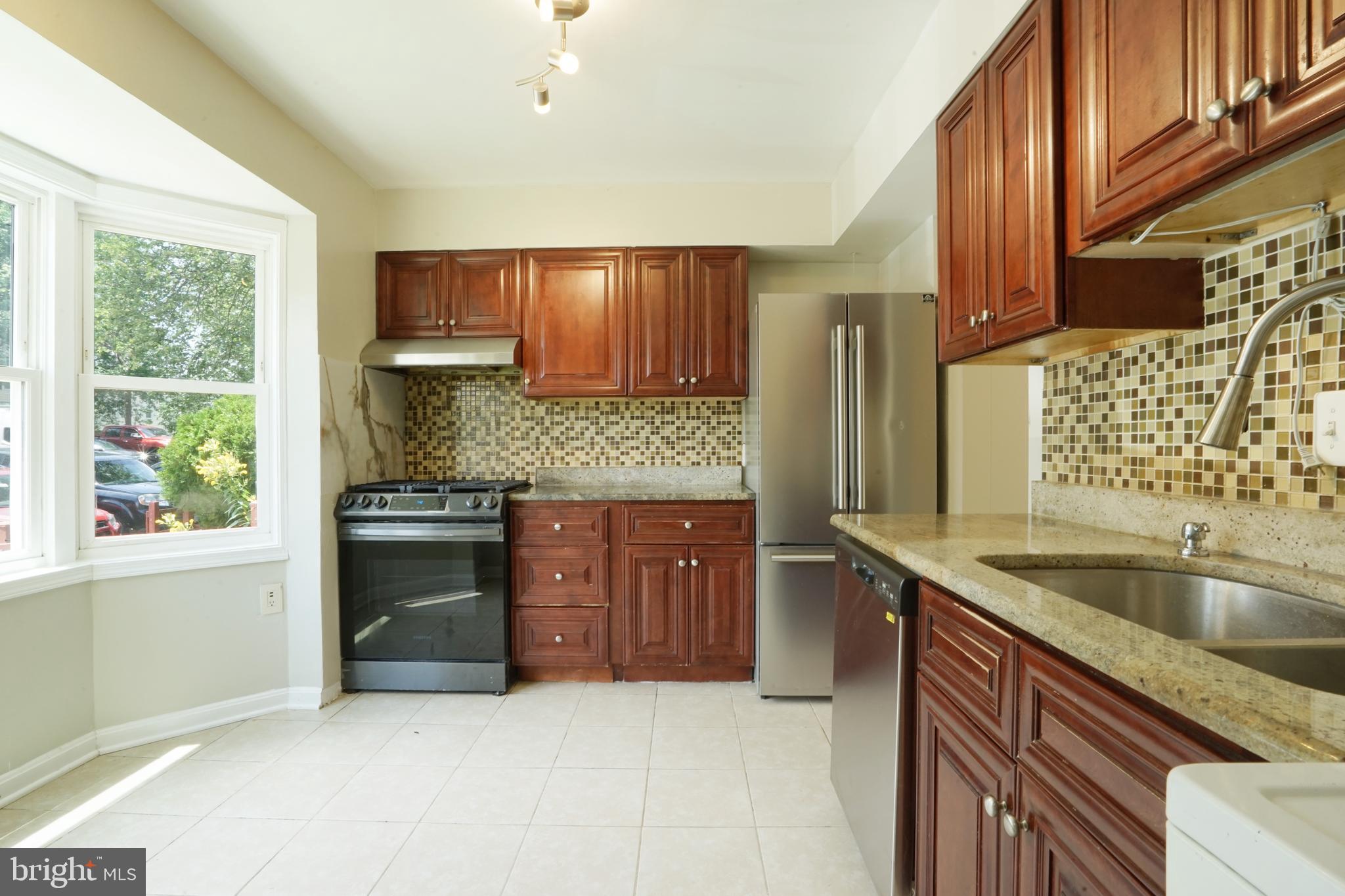 a kitchen with stainless steel appliances granite countertop a sink stove and cabinets