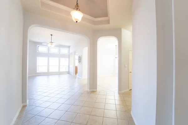 an empty room with windows and fireplace