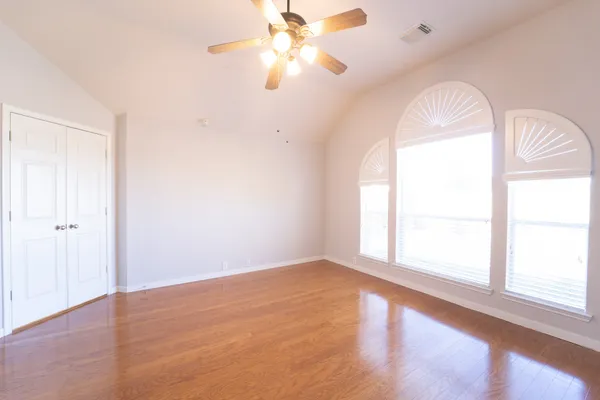 an empty room with a window and a fan
