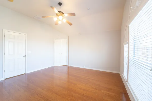 an empty room with a window and a fan