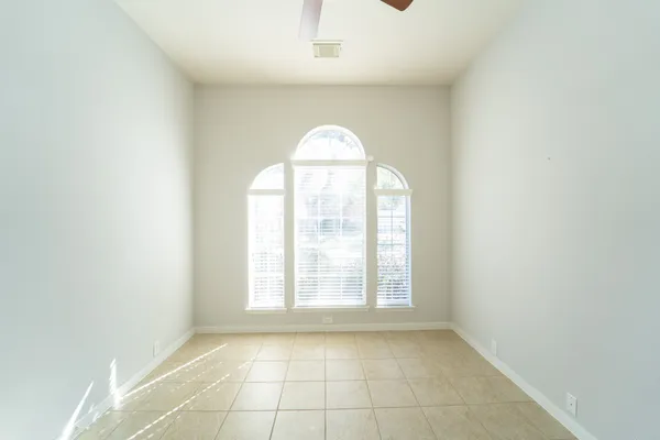 a view of an empty room with window and fire place