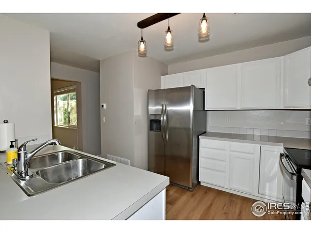 a kitchen with a sink refrigerator and window