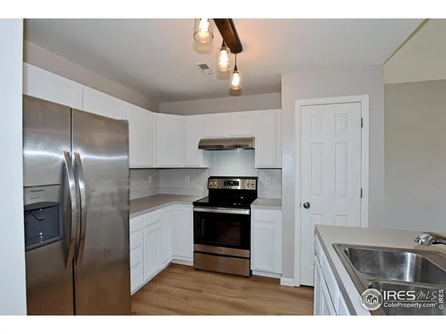 a kitchen with stainless steel appliances granite countertop a refrigerator a sink and a stove