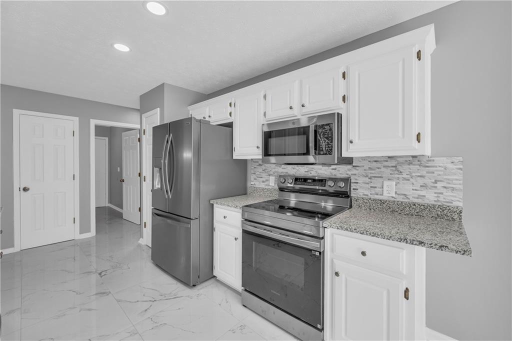 47 Chatham Court Jefferson, GA 30549 - Photo 36 of 69 a kitchen with stainless steel appliances granite countertop a refrigerator stove and microwave