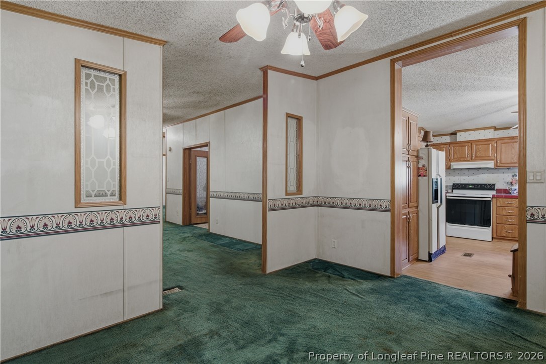7307 Roslin Farm Road Hope Mills, NC 28348 - Photo 15 of 46 a view of a refrigerator in kitchen and an empty room with wooden floor