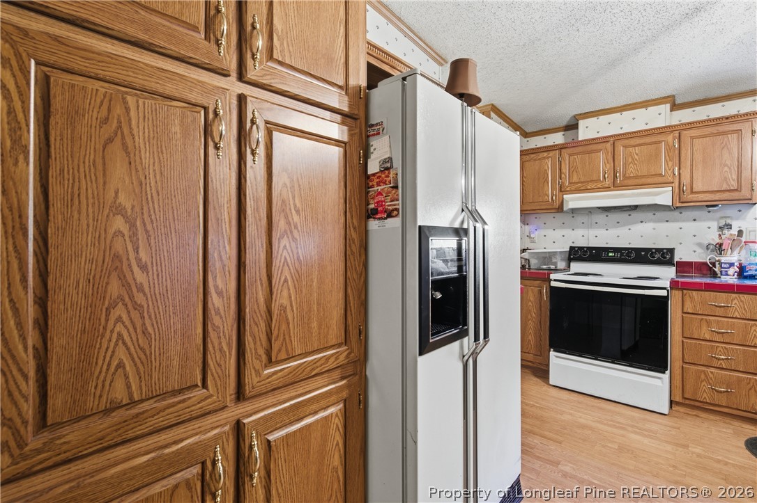 7307 Roslin Farm Road Hope Mills, NC 28348 - Photo 16 of 46 a kitchen with stainless steel appliances granite countertop a refrigerator and a stove
