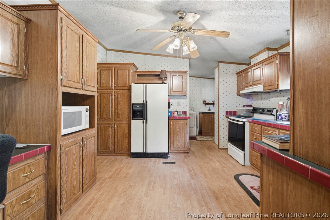 7307 Roslin Farm Road Hope Mills, NC 28348 - Photo 21 of 46 a kitchen with stainless steel appliances a refrigerator a stove microwave and cabinets