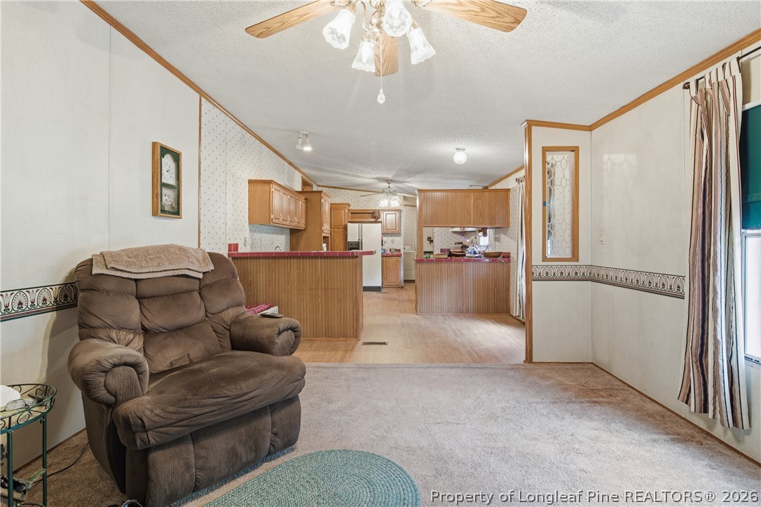 7307 Roslin Farm Road Hope Mills, NC 28348 - Photo 26 of 46 a living room with furniture a refrigerator and kitchen view