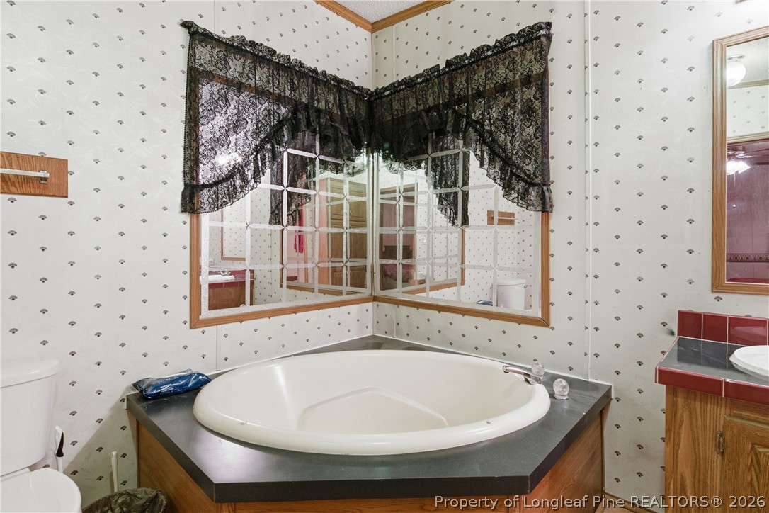 7307 Roslin Farm Road Hope Mills, NC 28348 - Photo 30 of 46 a view of a bathroom with a tub and shower