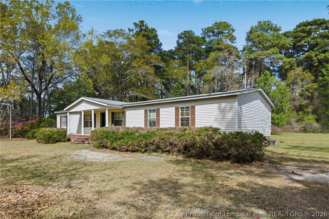 7307 Roslin Farm Road Hope Mills, NC 28348 - Photo 5 of 46 a front view of house with yard and trees around